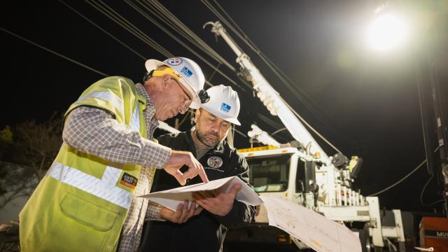 two LADWP employees reviewing paperwork at jobsite during night