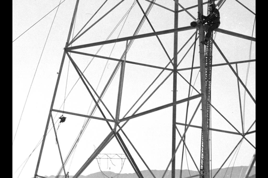 Workers constructing power transmission tower