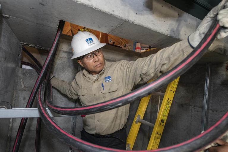 LADWP Electrician pulling cable in underground vault