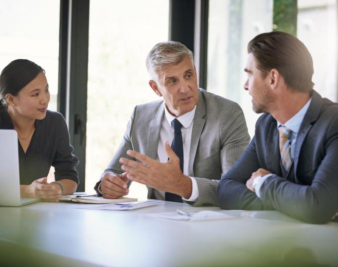 Three business people have a discussion.