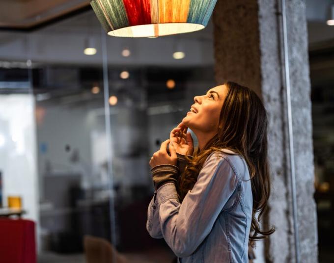 A woman looks up at an LED light.