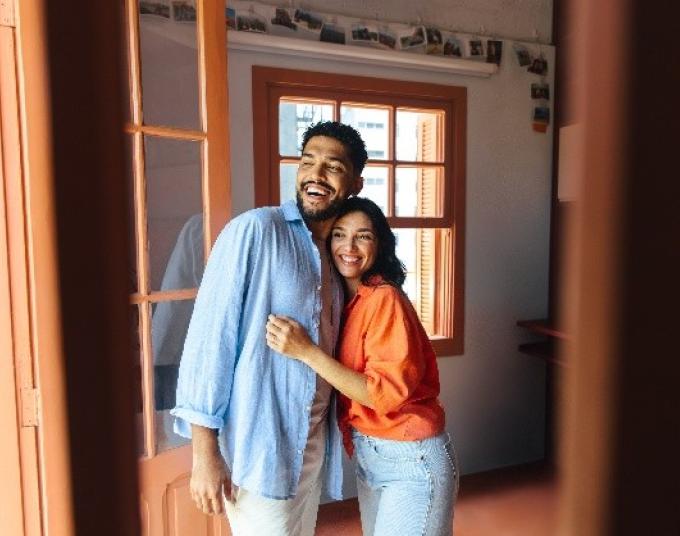 Man and woman standing in the doorway of a house.