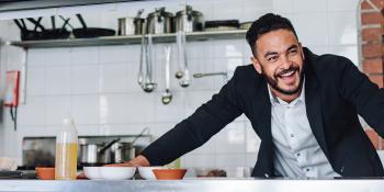 Image of man standing in restaurant kitchen.