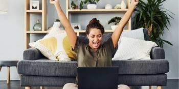Woman sitting in front of laptop with both arms up - Level Pay Program Banner