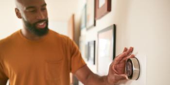 A man adjusting a thermostat