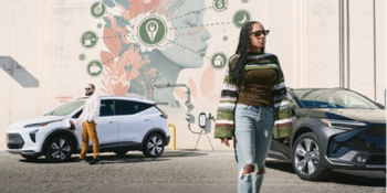 Young woman walking away from her electric vehicle after parking it in a lot with chargers.The wall behind them shows an eco-inspired mural with icons that relate to EV ownership.