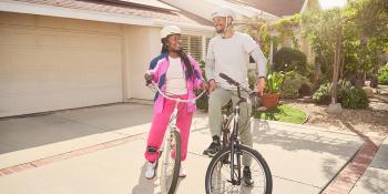 man and woman on bicycles in front of driveway