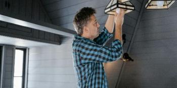 man installing light bulbs in light fixture