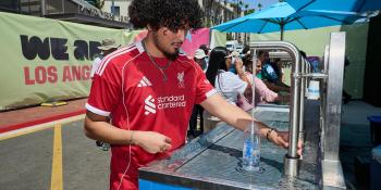 person filling up water bottle at event